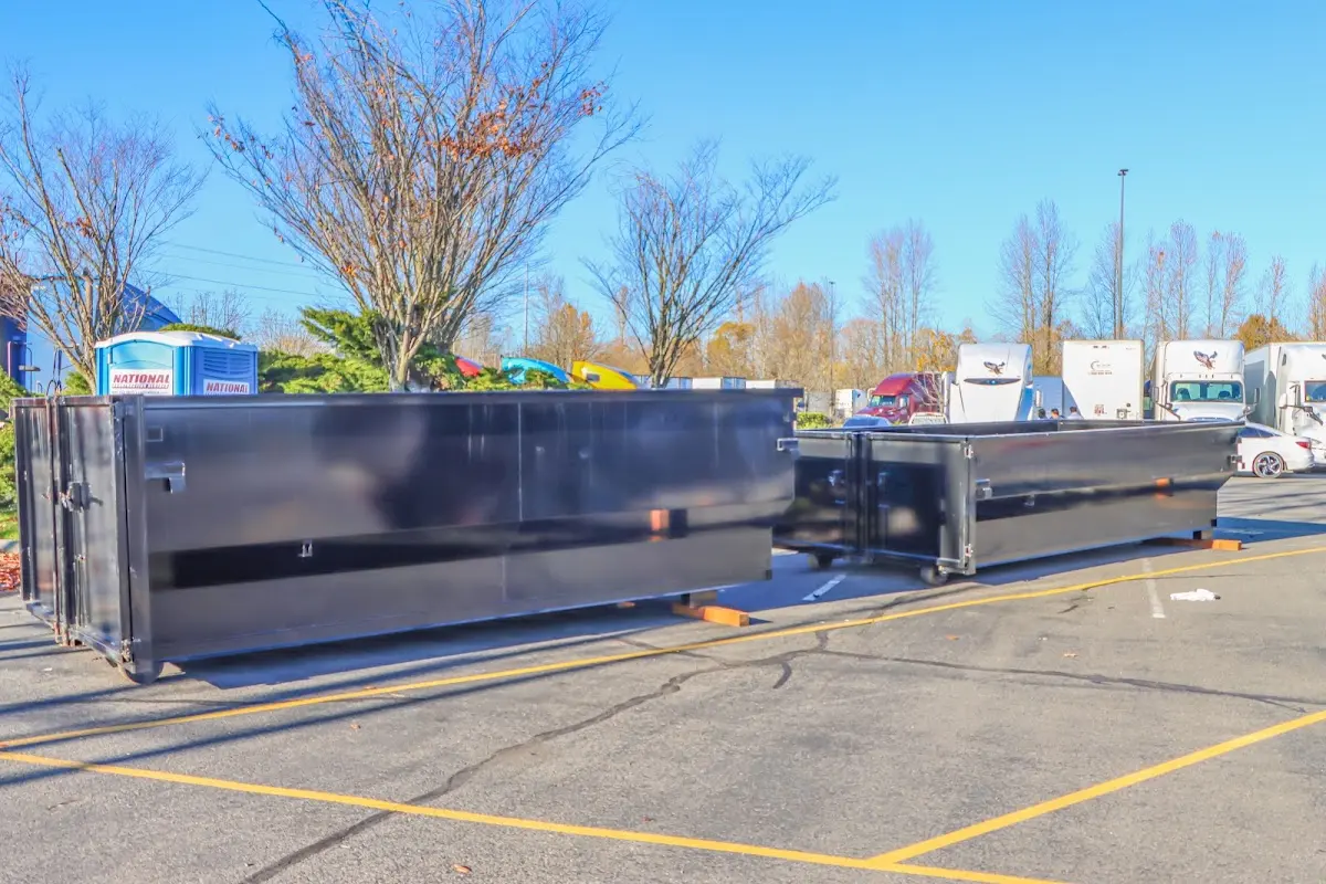 Professional dumpster rental service with roll-off container on residential driveway in Madisonville